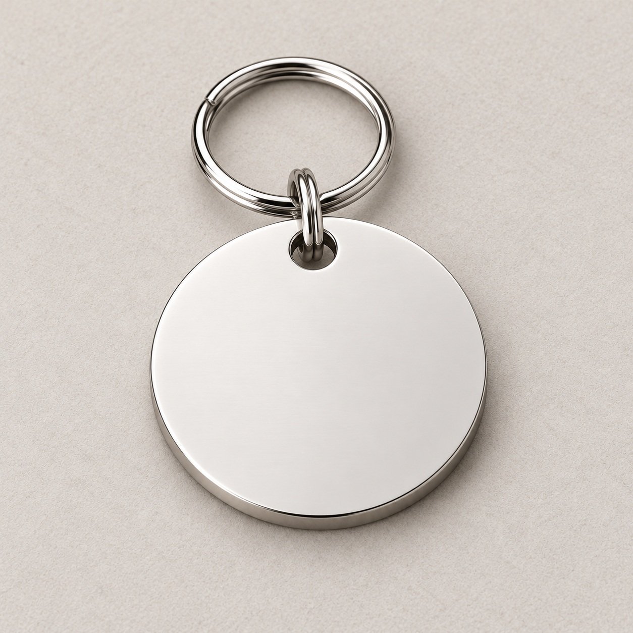 Plain silver reverse of the round stainless steel pet tag with its attachment ring.